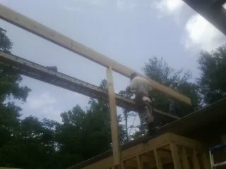 Carpenter setting a ridge beam over a new addition frame — Ice Dam Removal by Roofing Brothers in Luthersville