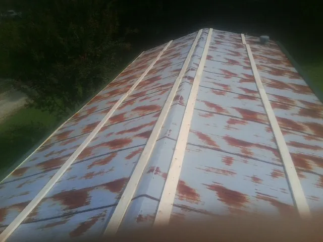 Rusted metal roof panels with new wood purlins before replacement — Storm Damage Roof Repair in Luthersville by Roofing Brothers