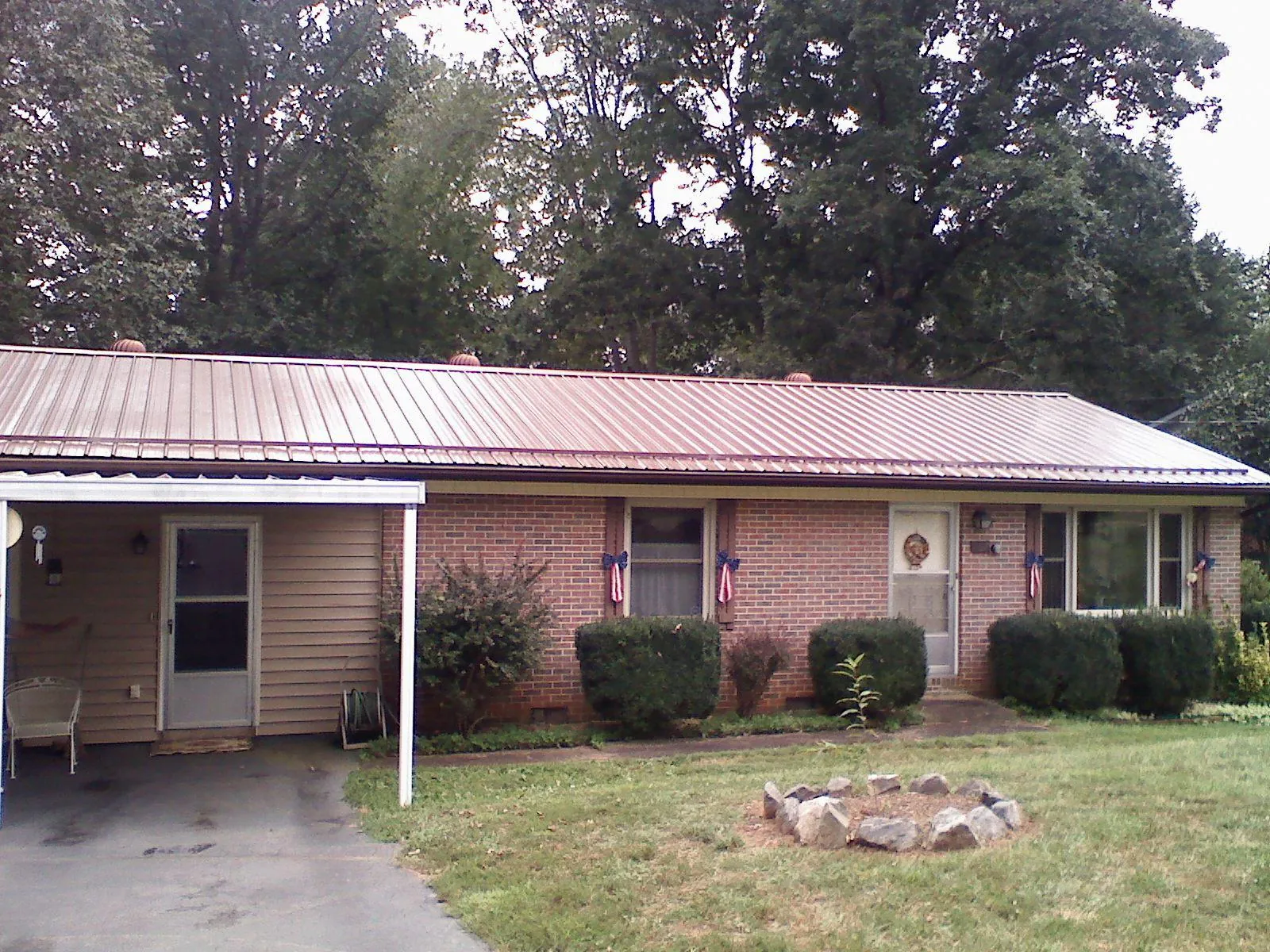 Bronze metal roof and carport on a brick ranch home — Roof Repair work by our crew in Luthersville